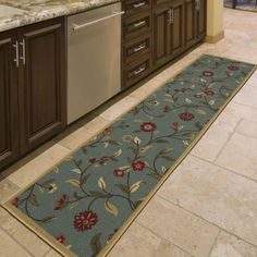 a kitchen with granite counter tops and wooden cabinets, along with a blue rug that has red flowers on it