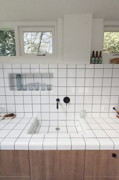 a kitchen with two sinks and tiled counter tops