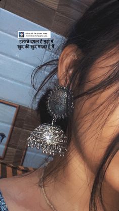 the woman is wearing two large earrings on her neck and one earring has been made out of metal