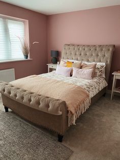 a large bed sitting next to a window in a room with carpeted flooring