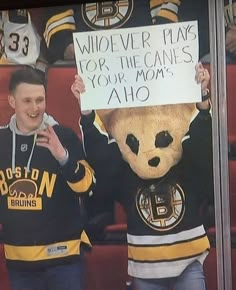 two hockey fans holding up a sign in the stands