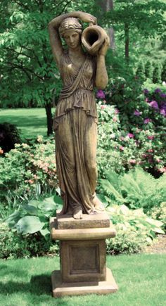 a statue in the middle of a lush green park