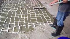 a man is using a brush to paint the floor with cement and concrete blocks on it