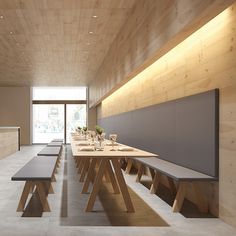 a long table and benches in a room with wood paneling on the wall behind it