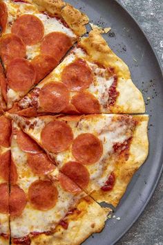 a pepperoni pizza cut into four slices on a plate