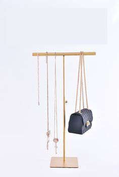 a jewelry rack with two purses hanging from it