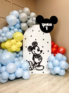 mickey mouse balloon arch with balloons in the background and an image of minnie mouse on it