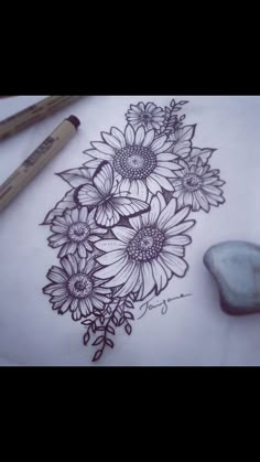 a drawing with flowers on paper next to two markers