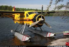 a small yellow plane sitting on top of a body of water