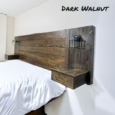 a bed with a wooden headboard and night stand on the wall next to it