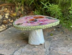 a small ceramic bird bath sitting on top of a rock