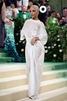 a woman in white dress standing on steps