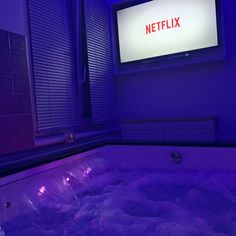 a bathtub filled with water next to a flat screen tv