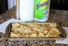 tortilla chips in a baking pan next to a bottle of laundry detergent