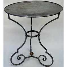 a round metal table with an iron base