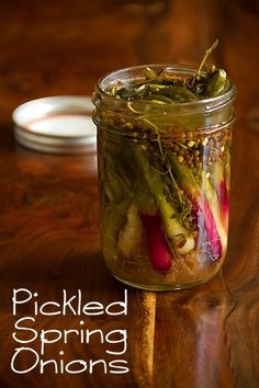 a jar filled with vegetables sitting on top of a wooden table