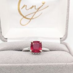 This beautiful ring features a sparkling red ruby in 14k white gold with a hidden diamond halo. A ring design perfect for an eye-catching engagement or anniversary. This ring also makes a beautiful July birthstone ring for your loved ones! The occasions to show off this ring are endless - mother's Day, graduation, wedding, birthday, date night, Christmas, etc. :) This ring is made with solid 14K Gold and naturally Earth-mined SI / G-H diamonds. As listed, this ring is ready to ship. If you're in Red Diamond Ring With Brilliant Cushion Cut, 14k White Gold Ruby Ring With Halo Setting, Red Cushion Cut Brilliant Diamond Ring, Red Cushion Cut Diamond Ring With Brilliant Cut, Gia Certified Red Ruby Ring For Anniversary, Red Ruby Ring With Vvs Clarity Diamond, Red Diamond Ring With Center Cushion Cut, Red Ruby Ring With Vvs Clarity, Red Ruby Ring With Vvs Clarity And Round Cut