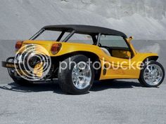 a yellow sports car parked in front of a mountain