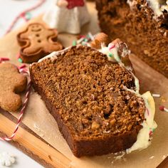 there is a piece of cake with icing on the cutting board next to some cookies