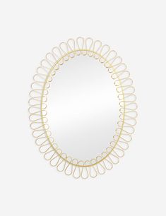 a round mirror with gold rings on the bottom and an oval frame in the middle