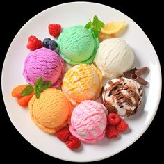 a white plate topped with lots of different flavored ice creams and fruit on top of each other