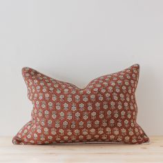 an orange and white pillow sitting on top of a wooden table