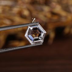 a close up of a diamond on a wire with other items in the background behind it