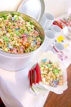 there is a bowl of cereal on the table next to plates and cups with spoons