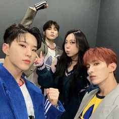 group of young men standing in front of a mirror with one pointing at the camera