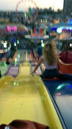 two girls are riding on the bumper to bumper cars at an amusement park in front of a ferris wheel