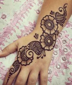 a woman's hand with henna tattoos on it, and an intricate design