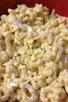 macaroni and cheese is mixed together in a red bowl, ready to be eaten