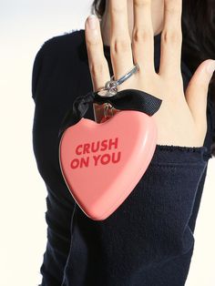 a woman holding a pink heart shaped object with the words crush on you written on it