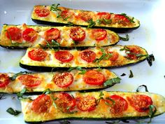 zucchini stuffed with tomatoes and basil on a white platter, ready to be eaten