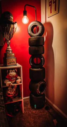 a stack of tires sitting next to a lamp in a room with a red wall