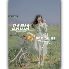 a woman standing next to a bike in a field