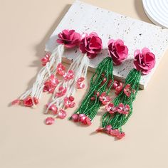 pink flowers are hanging from the side of a piece of paper