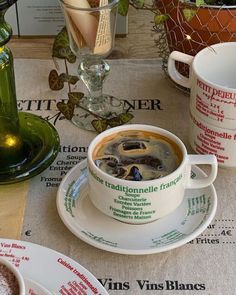 a table topped with cups and saucers filled with soup next to plates on top of a table