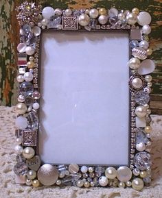 an ornate photo frame with pearls and jewels