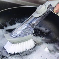 a person is using a brush to wash dishes