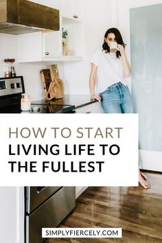 a woman standing at the kitchen counter drinking from a mug with text overlay reading how to start living life to the fullest