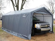 a black truck is parked in front of a gray tent on the side of a road