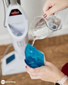 someone is pouring water into a blue container