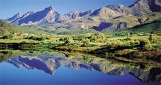 the mountains are reflected in the still water