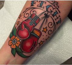 a tattoo with boxing gloves and flowers on it