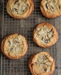 four chocolate chip cookies cooling on a wire rack