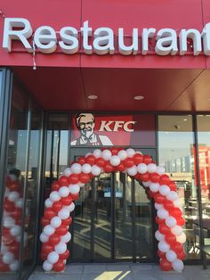 an entrance to a restaurant decorated with red, white and blue balloons in front of it