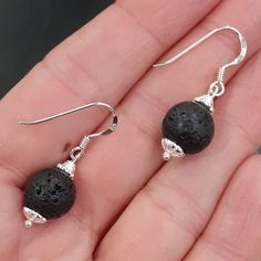 Beautiful Black Lava Stone Sterling Silver Drop Earrings with flower bead caps Perfect wear and gift for any occasions :)  Lava stones can be used as diffusers - put a drop of essential on the stones and enjoy the scent :) Ear wire length about 1.5 cm / 0.6 in Full length around 3.5 cm / 1.5 in Black Lava Stone beads are 10 mm You may find matching items in the shop. Made with love in a smoke and pet free home. Thank you for your interest in my items :) Black Spiritual Earrings For Gift, Spiritual Black Earrings For Gift, Elegant Black Lava Stone Jewelry, Black Natural Stone Dangle Earrings, Black Earrings With Natural Stones, Black Earrings With Natural Stones For Gift, Black Natural Stones Earrings For Gift, Stone Drop Earrings, Sterling Silver Drop Earrings