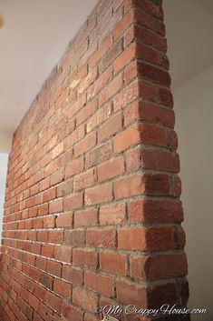 the corner of a brick wall in an empty room