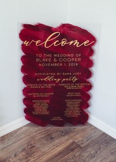 a wedding welcome sign is displayed on the wall in front of a wood floored room